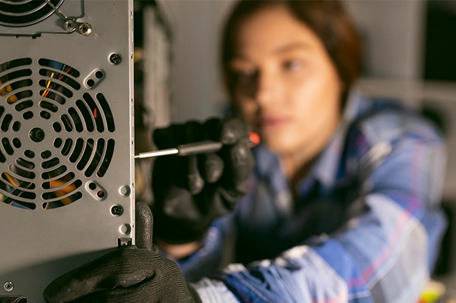 "Professional woman in black gloves servicing computer components with a screwdriver, featuring cloud hosting, business email, and cloud email by Elevation Technology.