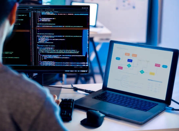 A professional stock photo of an IT professional working on software systems, representing managed IT services, cloud hosting, business email, and cloud email by Elevation Technology.