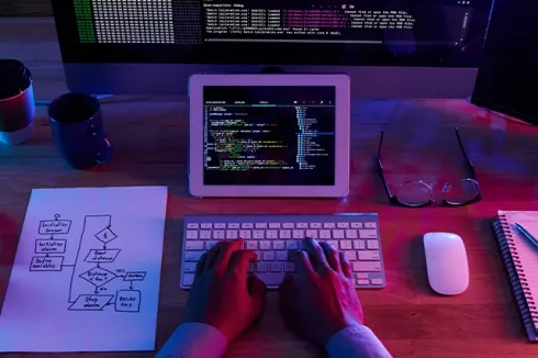 "Developer desk with laptop, tablet, and keyboard, highlighting IT solutions, cloud hosting, business email, and cloud email by Elevation Technology.