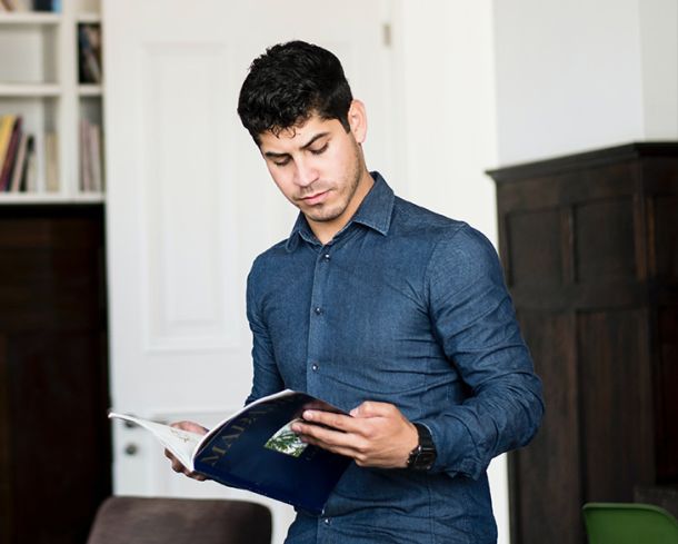  A focused professional reads a magazine, highlighting professional development, research, and IT industry knowledge.