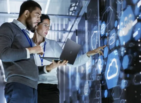 Technicians monitoring a server rack with a laptop using Elevate Technology and Elevation Technology to manage a cloud-based phone system, featuring Cloud PBX Phone System, Voicemail-to-email, and Hosted PBX data.