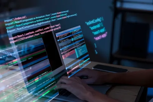 "Developer coding on a laptop, highlighting software development, cloud hosting, business email, and cloud email by Elevation Technology.