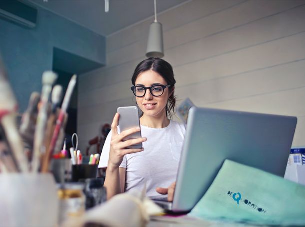  A focused professional works with a laptop and smartphone, highlighting digital productivity, IT management, and remote work.